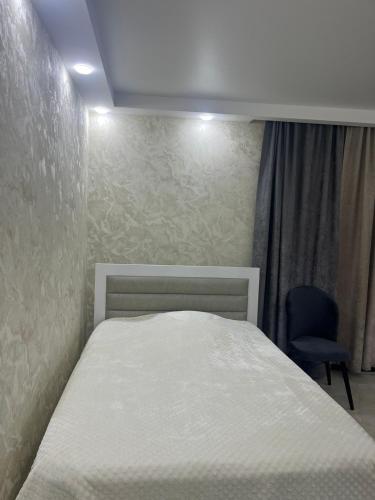 SuramiSurami的卧室配有白色的床和椅子