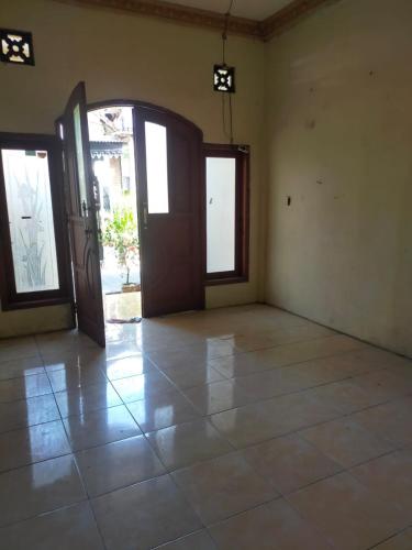 泗水banyu urip kidul regency的一间空房间,设有门,铺有瓷砖地板