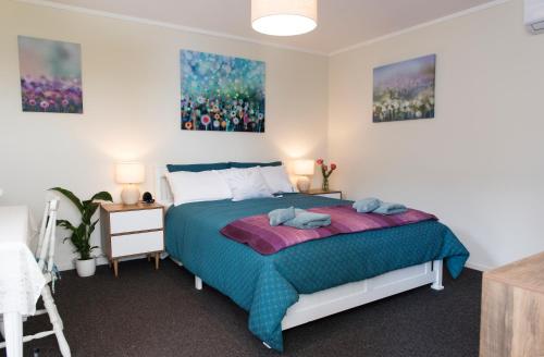 泰哈皮Hopwood Bed & Breakfast的卧室配有一张床,墙上挂有两幅画