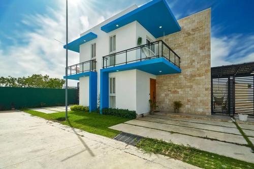 蓬塔卡纳SWEET DREAM VILLA的蓝色和白色的房子设有阳台