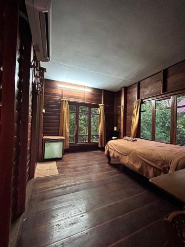 达叻府苏察纳里兰戈普度假村的一间卧室配有一张床和一台平面电视