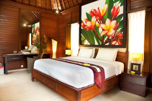 库塔捷鹏巴厘岛酒店的一间卧室配有一张带鲜花的床铺
