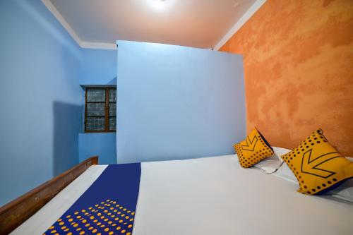 德奥加尔SPOT ON Shashi Prabha Palace的一间卧室配有一张黄色和蓝色床单的床