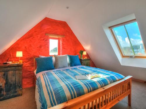 圣大卫Rhosson Chapel Cottage的一间卧室配有一张红色墙壁的床