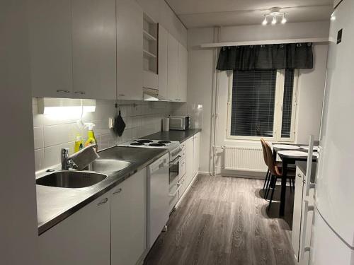 瓦萨Apartment Korsholma1的白色的厨房设有水槽和炉灶。
