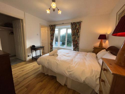 戈尔韦Wild Atlantic Way Cottage Galway的卧室配有白色的床和窗户。