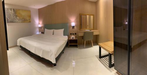 罗东镇米淇旅店 - 罗东馆 的一间卧室配有一张床、一张书桌和一面镜子