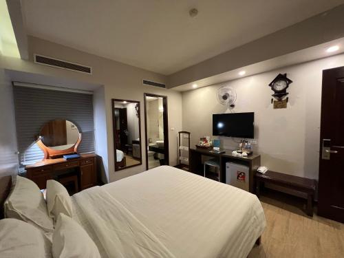河内A25 Hotel - 88 Nguyễn Khuyến的卧室配有白色的床和电视。