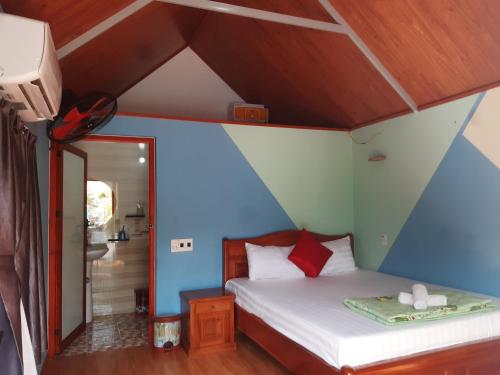 吉婆岛Cat Ba Park Homestay的一间卧室配有一张蓝色墙壁的床