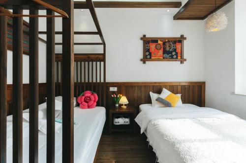 张家界张家界加州时光咖啡旅馆的一间卧室设有两张床和梯子