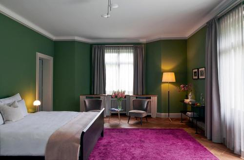苏黎世Signau House & Garden Boutique Hotel Zürich的一间卧室设有绿色的墙壁和一张紫色地毯。