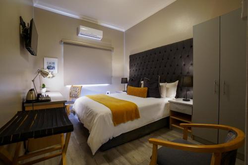 米德兰Inani Hotel Gallagher的酒店客房设有一张大床和一张书桌。