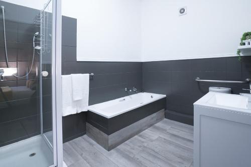 米德兰Inani Hotel Gallagher的带浴缸和盥洗盆的浴室
