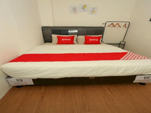 雅加达Capital O 93261 Fresh Hotel Near Stasiun Jakarta Kota的一张带两个红色枕头的床