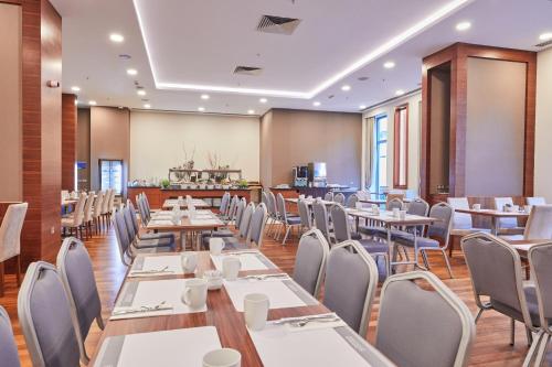 伊斯坦布尔德德曼博斯坦斯公园酒店的用餐室配有桌椅