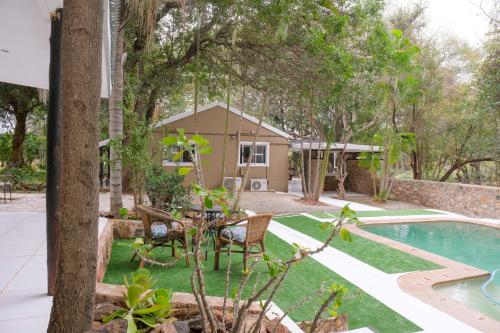 侯斯普瑞特Kadima Safari Lodge的后院设有绿色草坪和游泳池