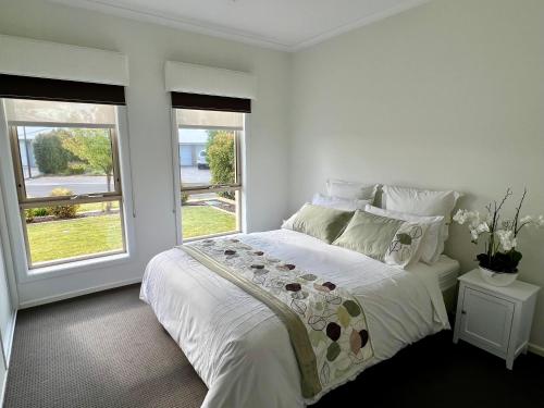 塔南达Premium Barossa Getaway的一间白色卧室,配有床和2个窗户