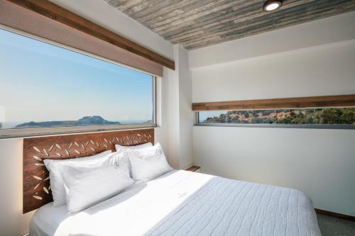 普拉基亚斯DOMUS AESTAS Luxury Residences的一间卧室设有一张大床和大窗户
