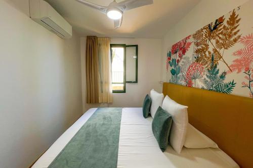英格兰海滩Apartamentos Cordial Judoca Beach的一间卧室配有一张大床,墙上挂着一幅大画