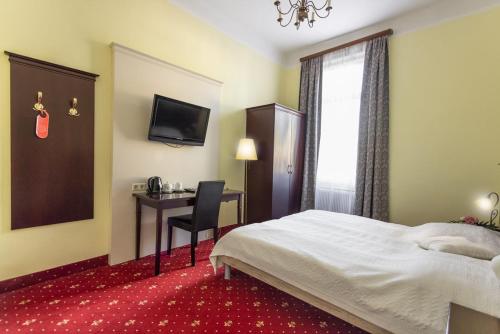 维也纳Hotel Viktoria Schönbrunn的配有一张床和一张书桌的酒店客房