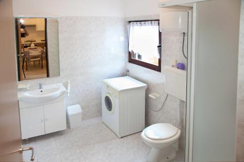 利兹扬Kucica Lusi的浴室配有白色卫生间和盥洗盆。