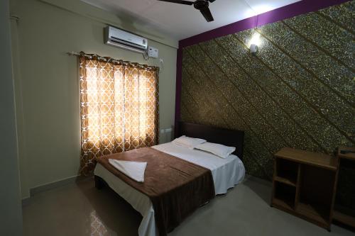卡尔佩特塔Wayanad regal residency的一间卧室配有床和带窗帘的窗户