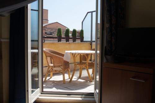 罗马风中玫瑰酒店的阳台配有桌椅和电视。