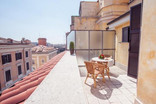 罗马风中玫瑰酒店的大楼内的阳台配有桌椅