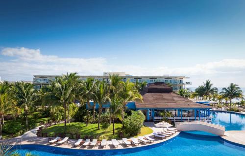 莫雷洛斯港坎昆海滨阿祖尔海滩度假酒店 - 卡利斯玛美食全包的享有度假村的空中景致,设有椅子和游泳池