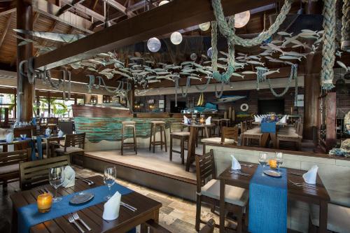 莫雷洛斯港坎昆海滨阿祖尔海滩度假酒店 - 卡利斯玛美食全包的一间带桌椅的餐厅和一间酒吧