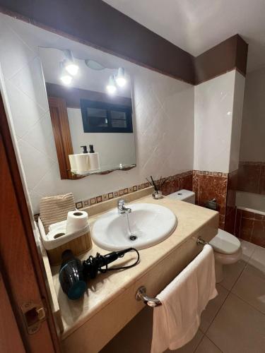 普拉亚布兰卡Villa Margherita的一间带水槽、镜子和卫生间的浴室