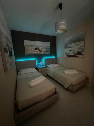 普拉亚布兰卡Villa Margherita的蓝色灯的客房内的两张床