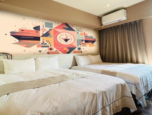 台中市达斯旅店的酒店客房设有两张床,墙上挂有绘画作品