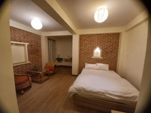 帕坦Hiti fusa的一间卧室设有一张床和砖墙