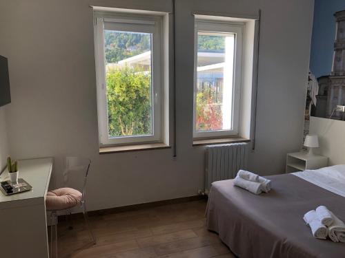 拉奎拉里维拉门酒店的一间卧室设有2个窗户、一张床和一张书桌