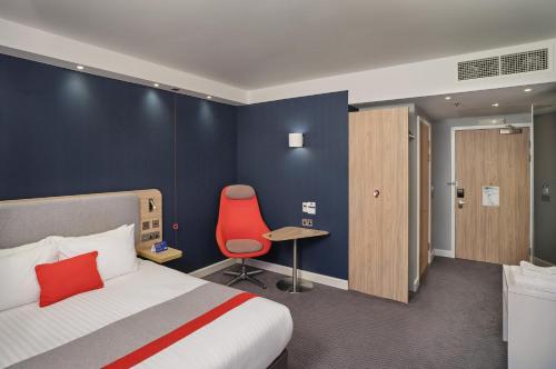 伯明翰智选假日酒店-伯明翰市中心的酒店客房,配有一张床和一张红色椅子
