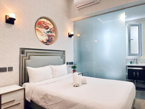 新加坡Kam Leng Hotel的卧室配有一张白色大床和镜子