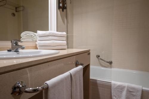 阿尔考斯布里Hotel Alcossebre的浴室配有水槽、浴缸和毛巾