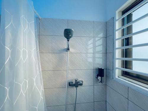 AdentanRakka Guest House的带淋浴和浴帘的浴室