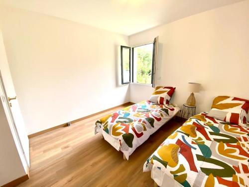 BessinesLa Bessinoise, 4chambres, Fibre optique et canoe NIORT & BESSINES的一间卧室设有两张床和窗户。