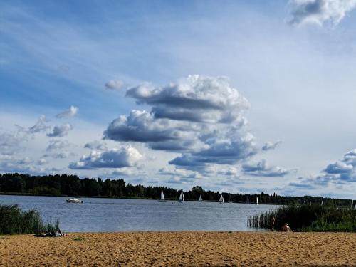 斯诺科Apartament Nad Zalewem Zegrzyńskim的一片湖上满是帆船的海滩,天空阴郁