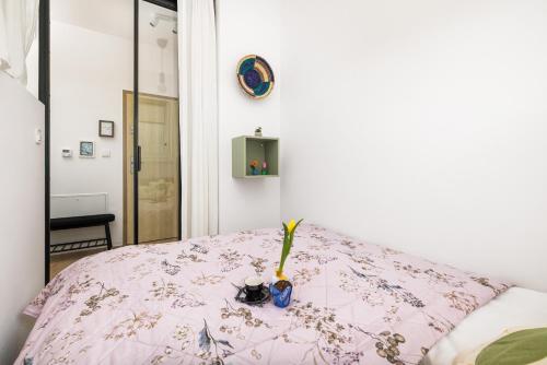 尤斯托尼莫斯基Szprotka Apartment with Air-Conditioning & Parking by Renters的一张带粉色毯子的床,上面有花瓶