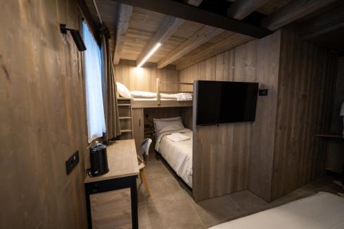 蓬泰迪莱尼奥Le Suites de San Campel RTA的小房间设有一张床和一台平面电视