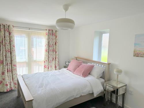 德比Superb 2 bed 2 bathroom free parking的一间卧室配有带白色床单和粉红色枕头的床。