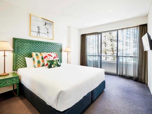 悉尼悉尼曼利海滩塞贝尔酒店的一间卧室设有一张大床和一个大窗户