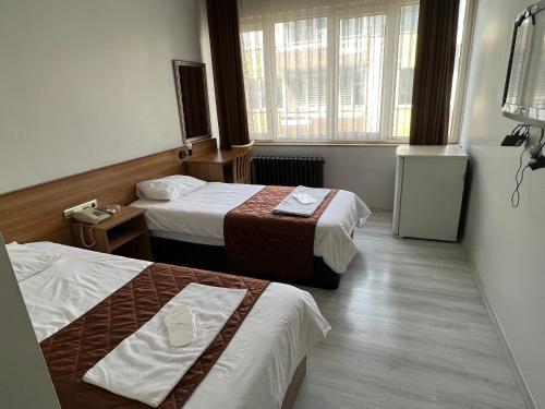 科贾埃利Altinnal Hotel的酒店客房设有两张床和窗户。