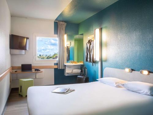 巴黎巴黎伯特蒙马​​特宜必思快捷酒店的客房设有床、窗户和浴室。