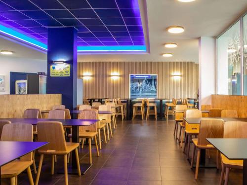 巴黎巴黎伯特蒙马​​特宜必思快捷酒店的一间配备有桌椅和紫色照明的用餐室