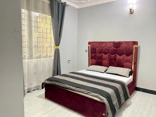KiraTREAT HOMIES的一间卧室配有一张带红色床头板的床和窗户