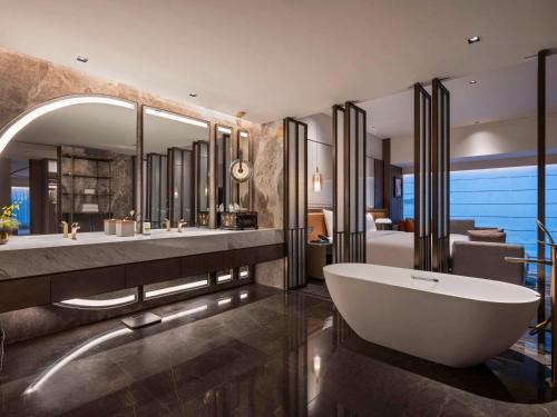 泉州泉州水头铂尔曼酒店的浴室配有两个盥洗盆和浴缸。